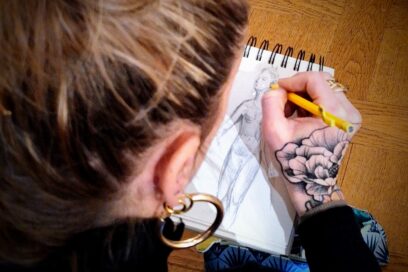 Une croqueuse dessine au crayon sur un carnet dans une salle du musée. Ils s'agit de la sculpture "Diane chasseresse" de Houdon. - Agrandir l'image, fenêtre modale