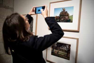 Une visiteuse prend une photo de l'exposition avec son smartphone - Enlarge image 12 on 20, modal window
