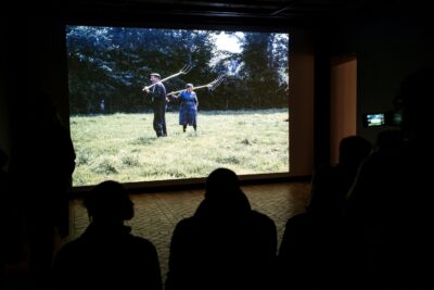 Des visiteurs regardent une projection de photographies - Enlarge image 11 on 20, modal window